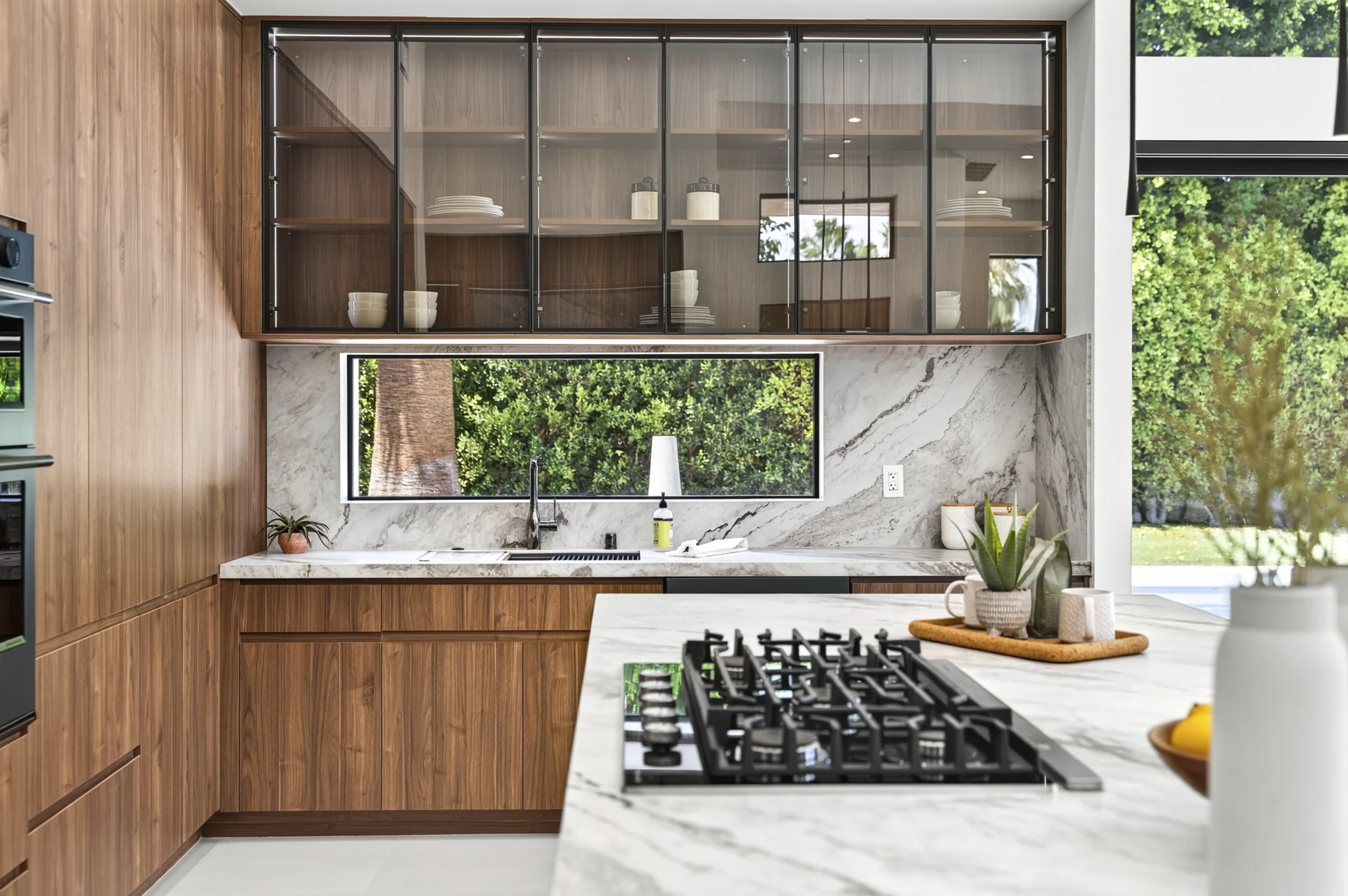 Alameda: kitchen cabinetry, stone backsplash and cooktop