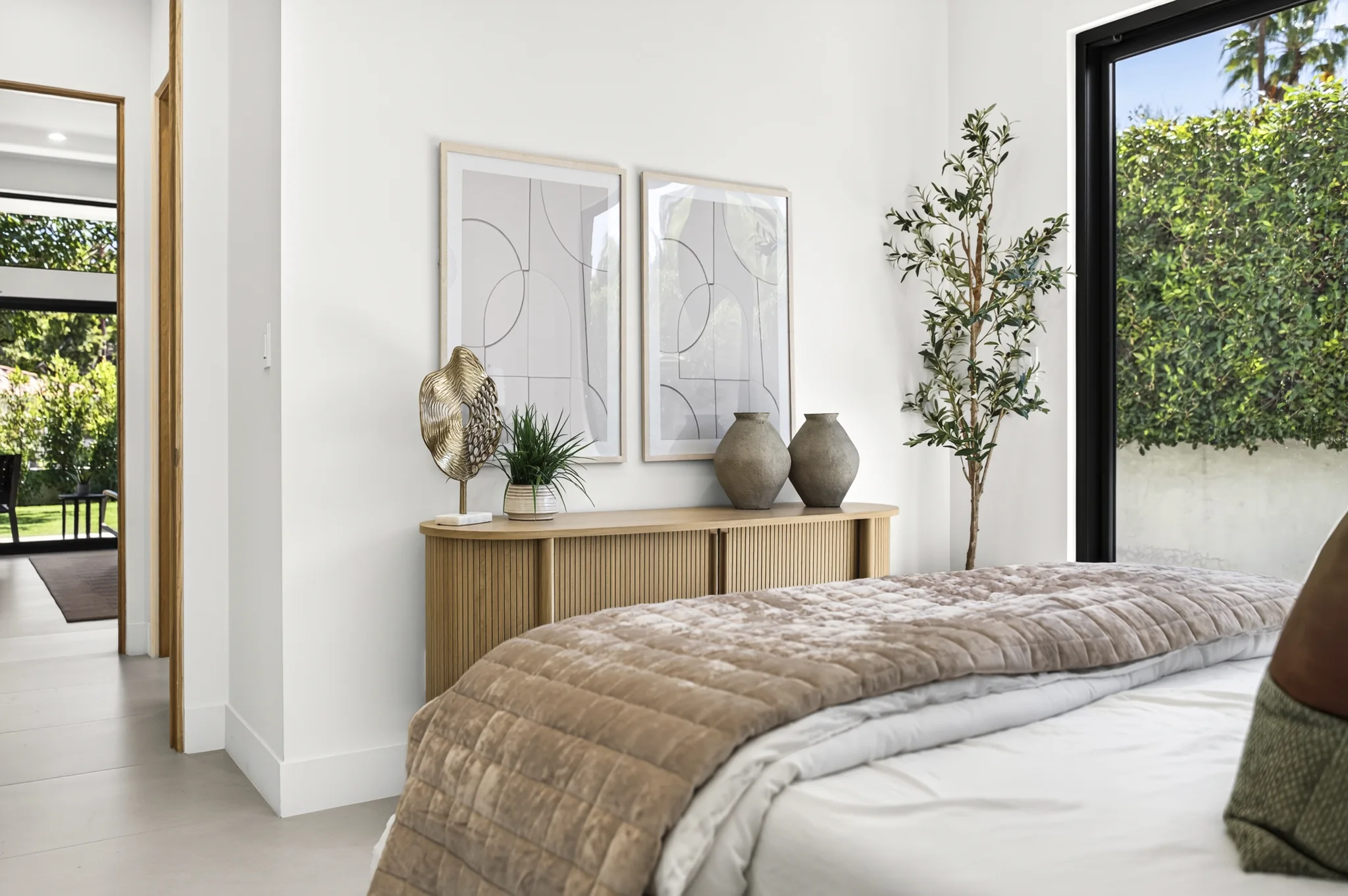 Alameda: bedroom with a neutral upholstered bed and large windows