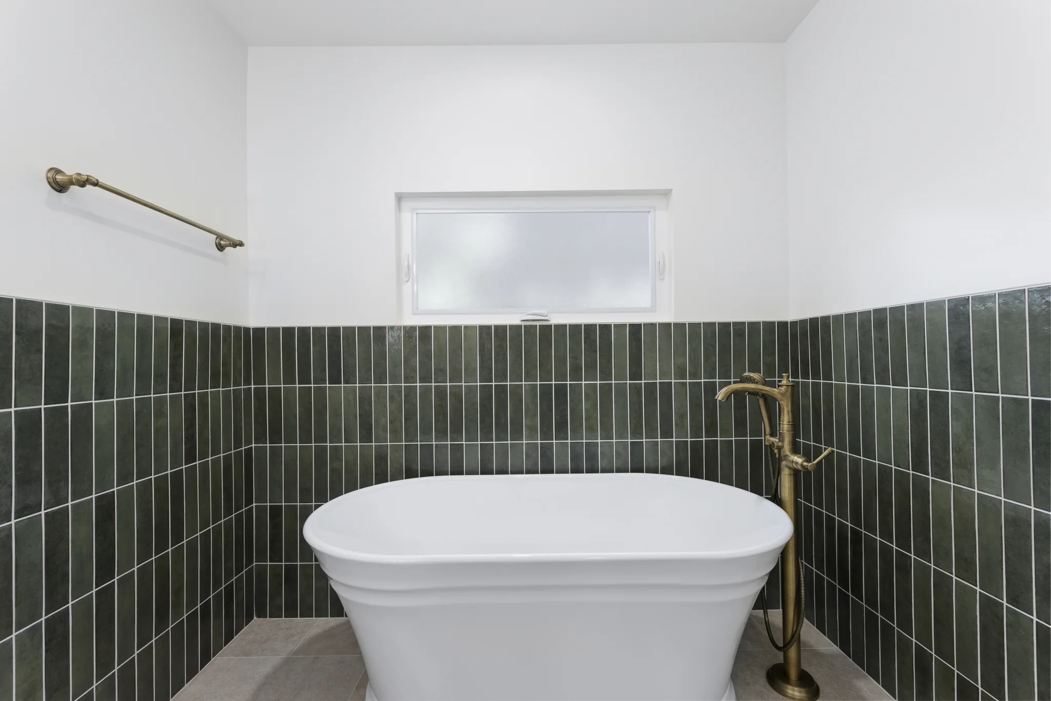 Álvarez: freestanding bath beside green wall tile