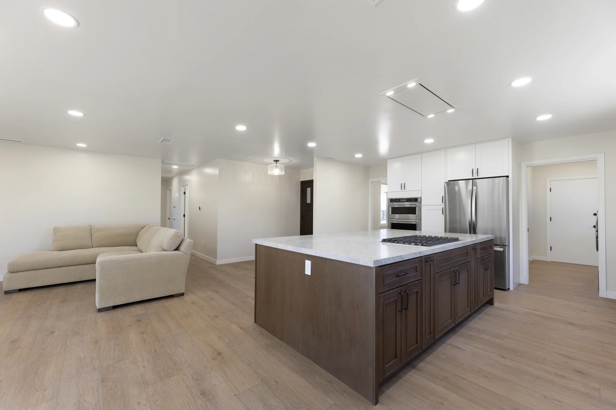 Álvarez: open kitchen with a timber island, pale counters and adjoining living area