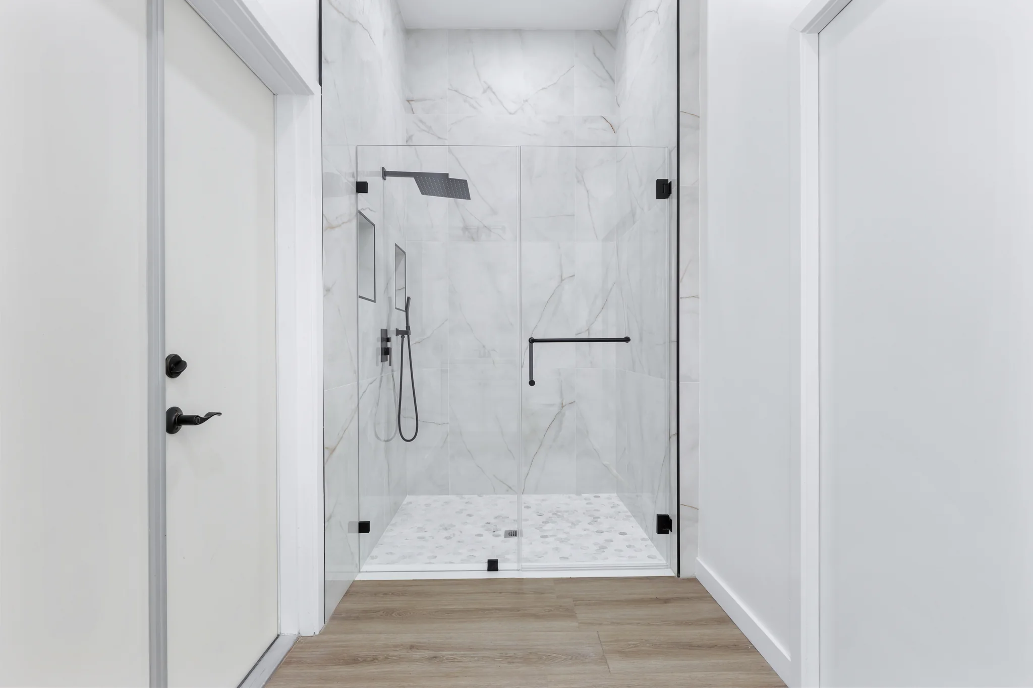 Conata: bathroom with a glass shower enclosure and pale tile