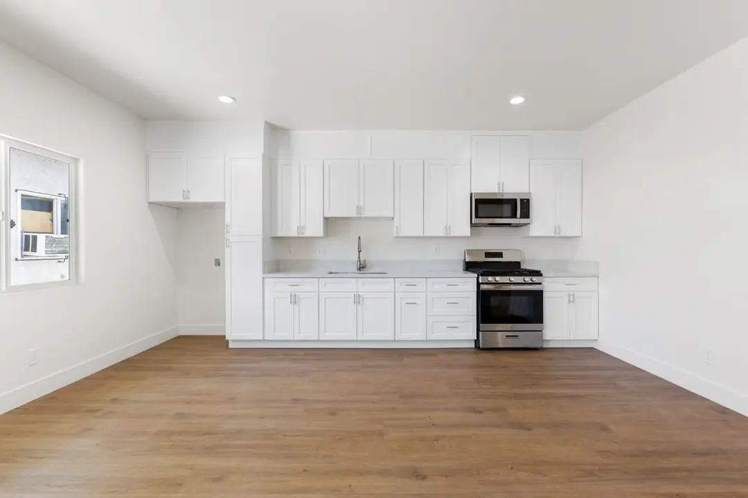 20th St.: white kitchen viewed across open room