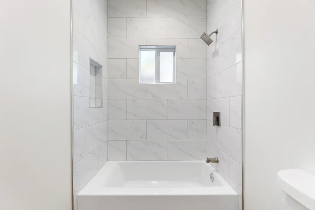20th St.: tiled tub surround beneath high window
